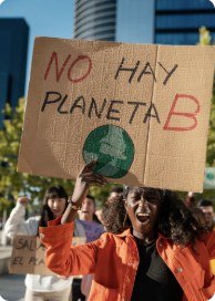 A young woman at a climate march holding a cardboard sign reading "No hay planeta B"